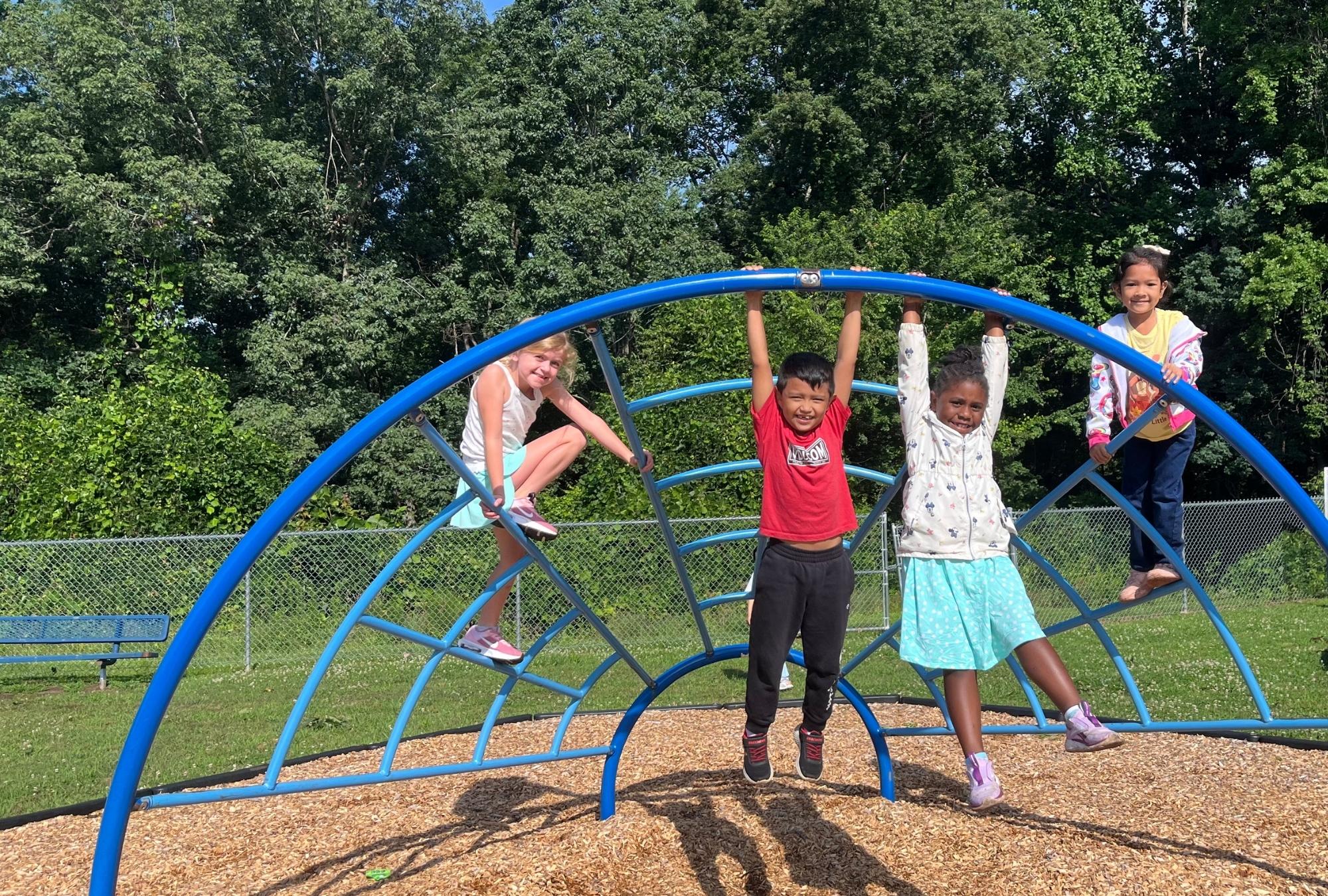 camp irock children hanging on the climber on the playground