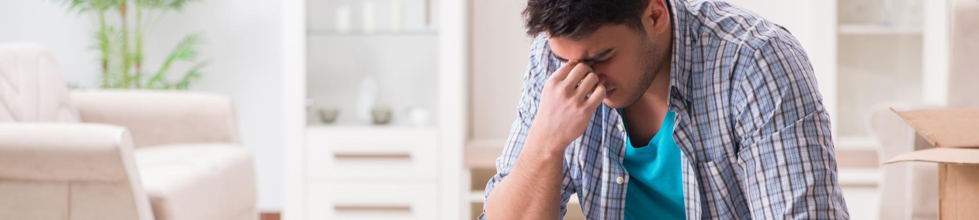 A man sits with his head in his hand