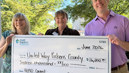 Karen Culley, Julie Capaldi, and Trent Acker pose for a check presentation photo.